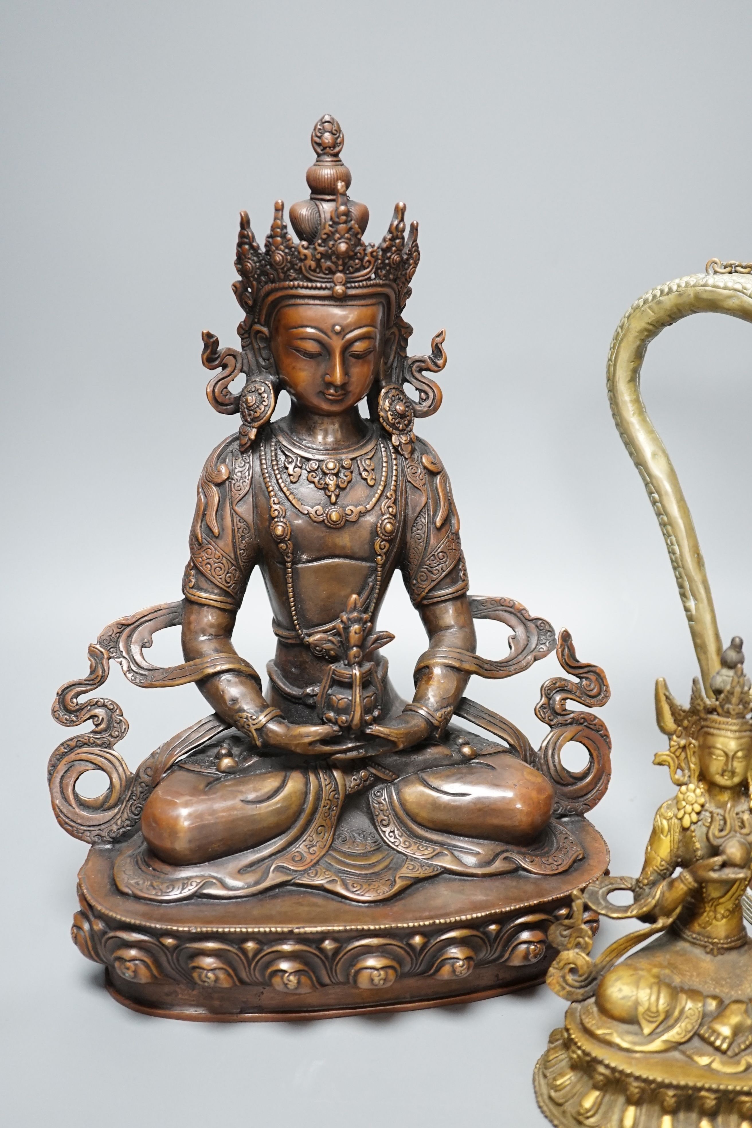 A Tibetan copper and brass ewer, together with a gilt-metal bodhisattva and another bronze bodhisattva, tallest 31cm